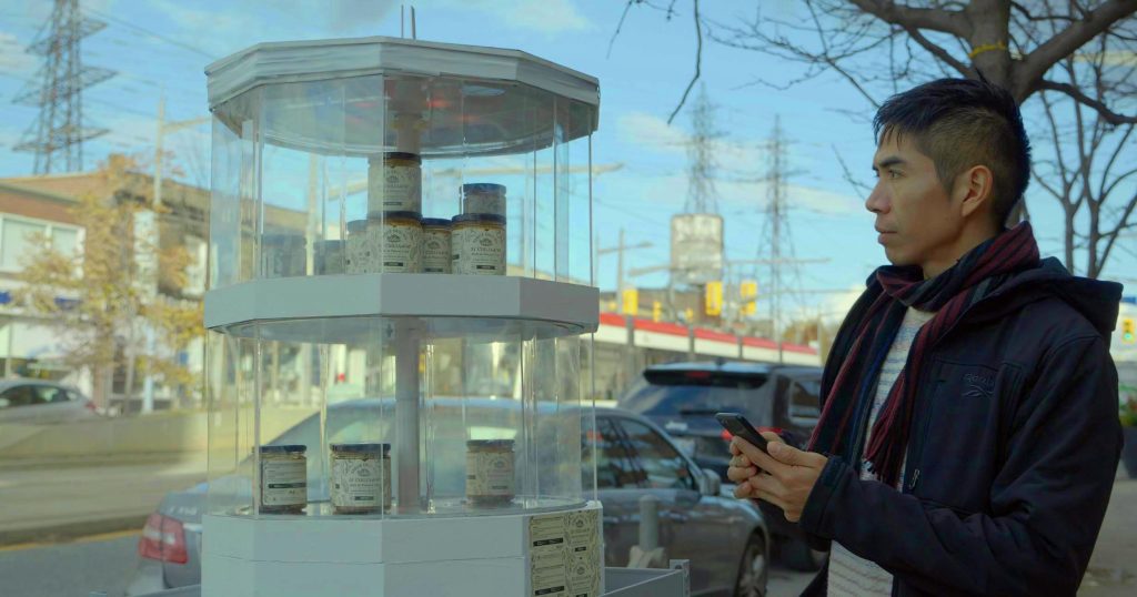 a man holding a phone and looking at bottled items
